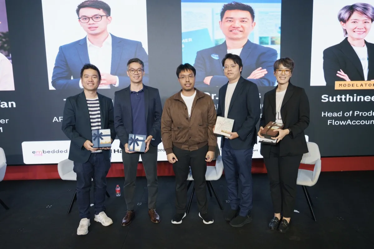 คน 5 คนยืนเรียงกันบนเวทีหลังจบช่วง 4 คนถือกล่องของที่ระลึก